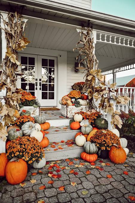 A fall porch arrangement with pumpkins and autumn accents